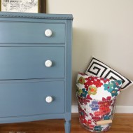 A smokey blue dresser with white knobs
