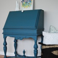 An antique secretary desk in a deep teal