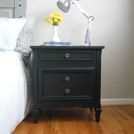 A pair of black nightstands with emerald knobs