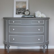 A grey demi lune dresser with white accents