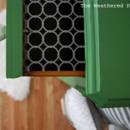 A mossy green dresser with white rose knobs