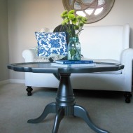 A metallic, pedestal coffee table