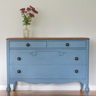A smokey blue dresser with a stained top